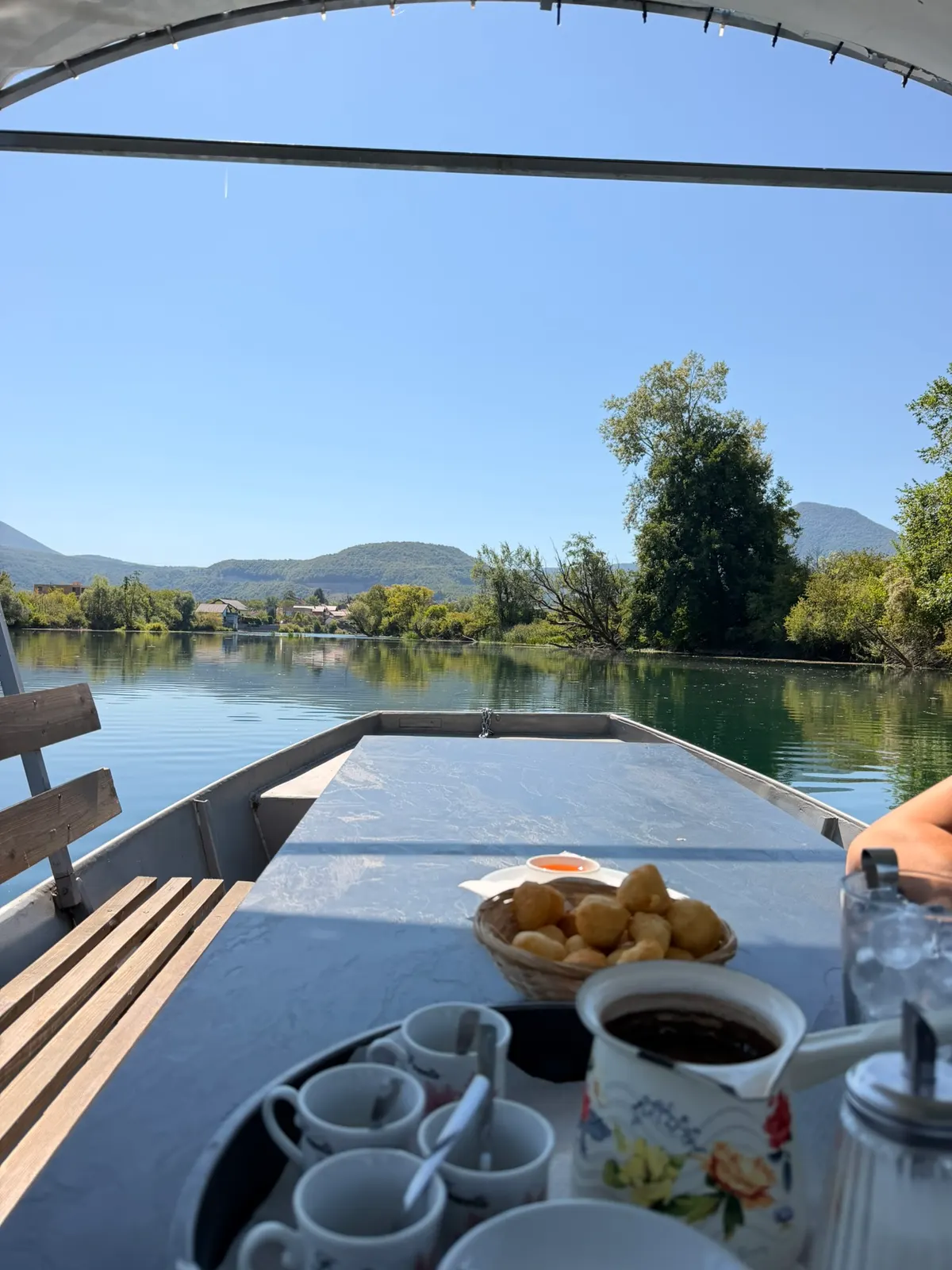 Kafa i uštipci na stolu lađe Sojenice, s pogledom na Unu